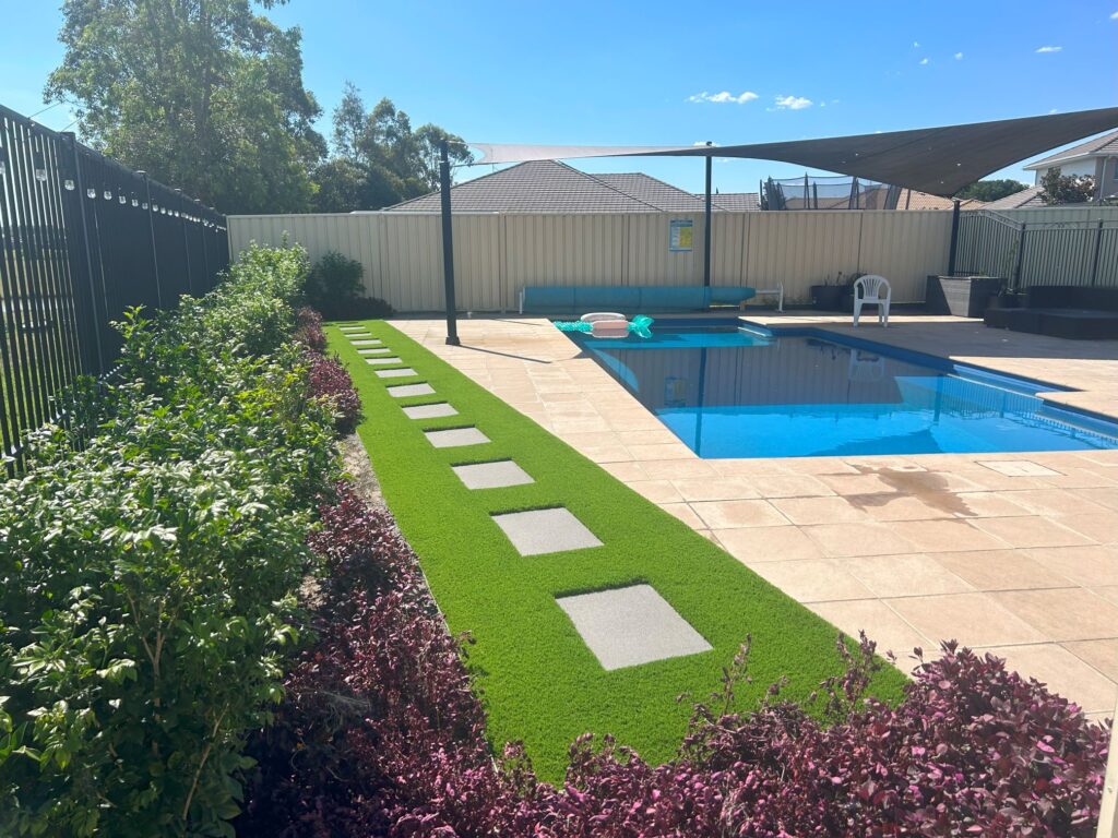 Synthetic grass around pavers near pool